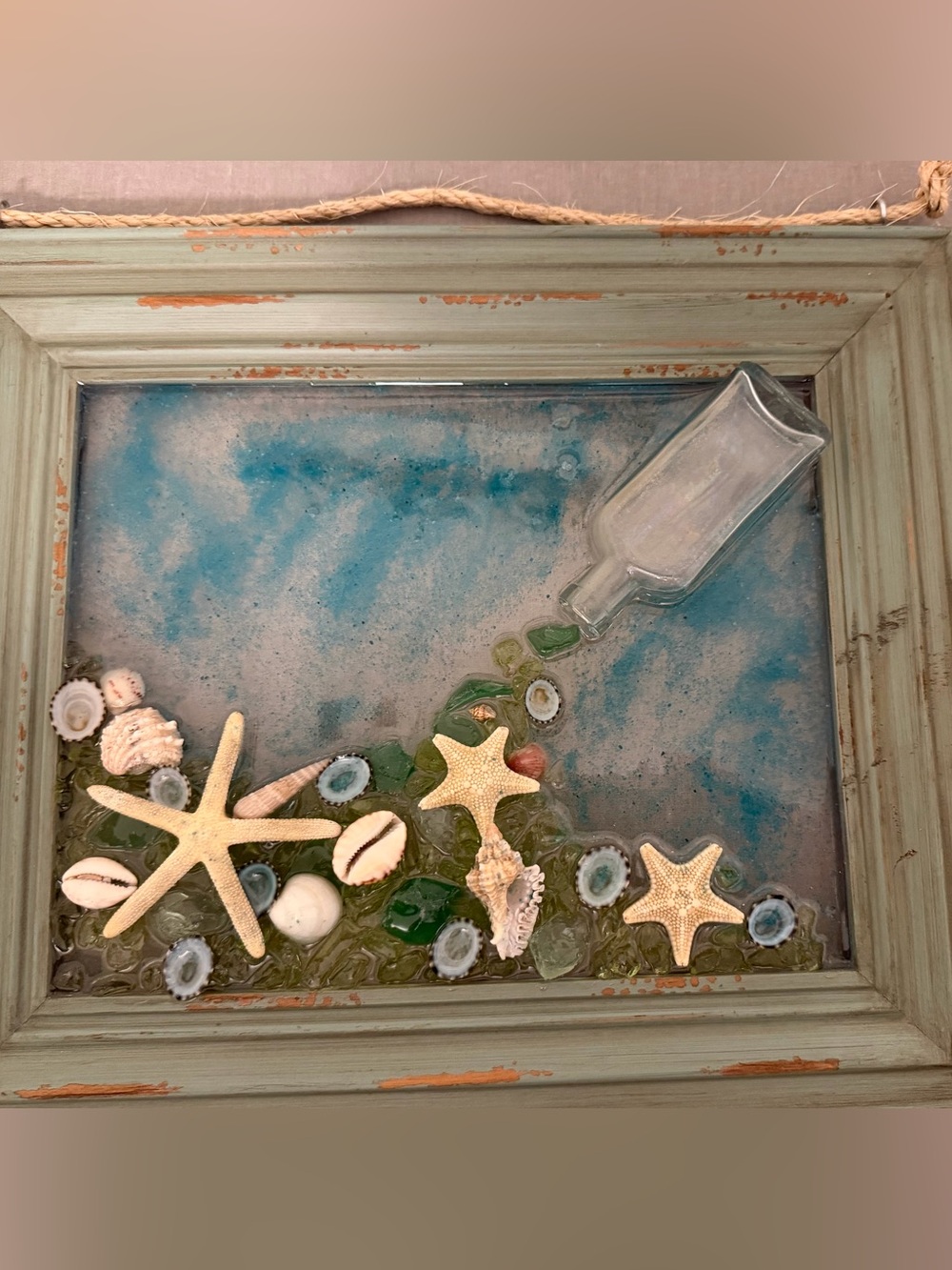 Seashell decor.  Acrylic pour on glass framed with rustic green frame and rope.